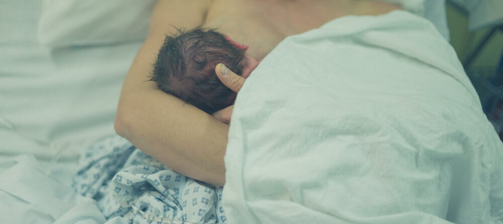 A new mother breastfeeds her newborn in the hospital immediately after birth