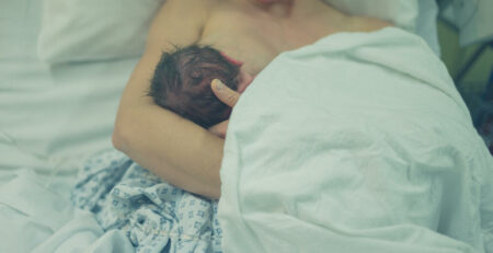 A new mother breastfeeds her newborn in the hospital immediately after birth