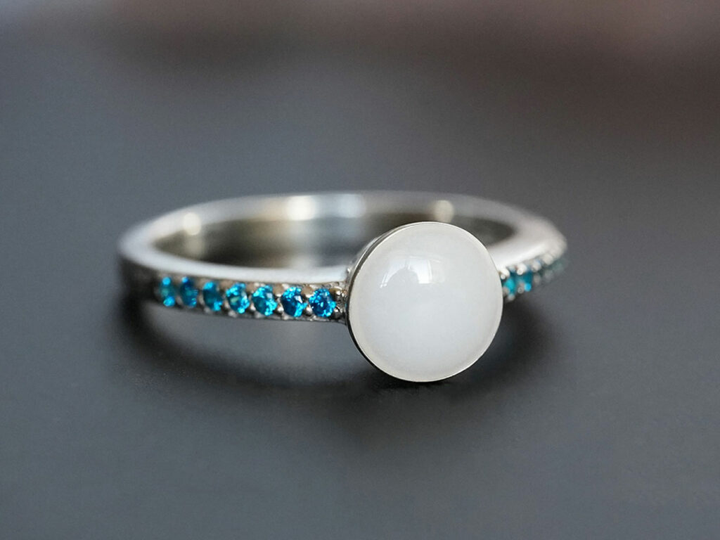 breastmilk jewelry ring with fine band blue zircon birth month color crystals and round breastmilk stone from Keepsakemom
