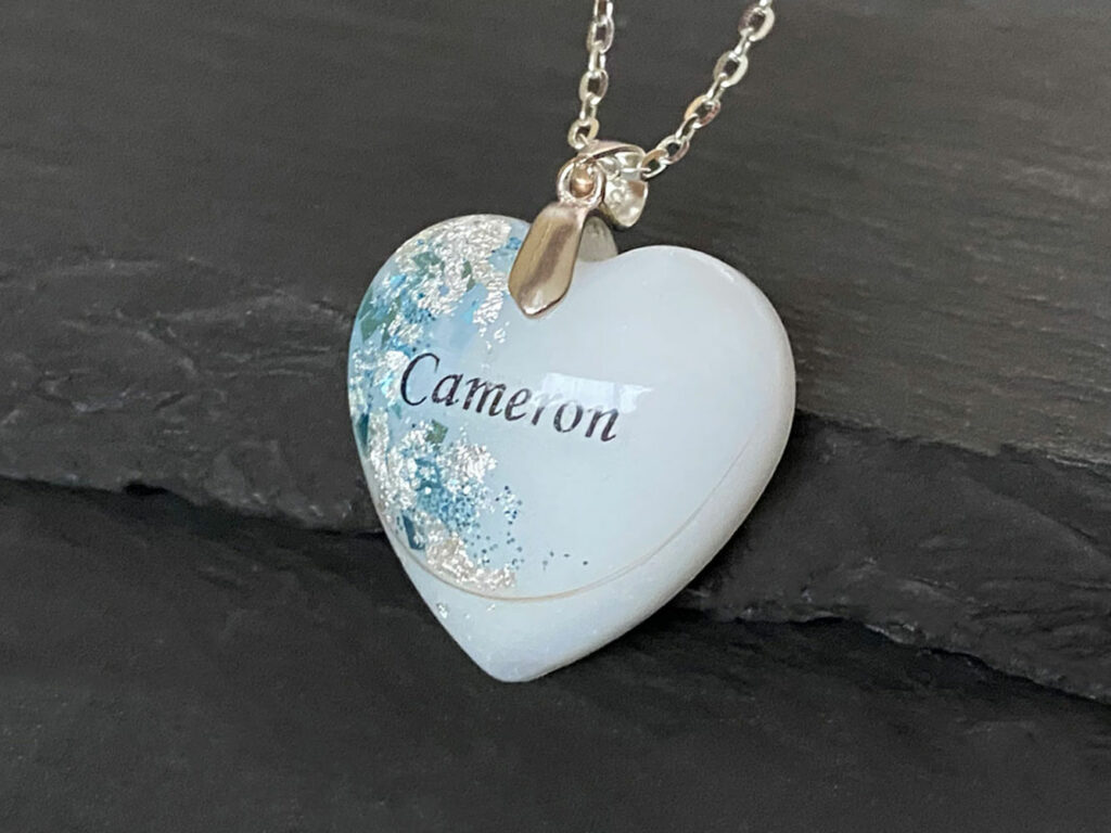 Breastmilk jewelry silver heart necklace with blue aquamarine March birth month color flakes and baby's name from KeepsakeMom