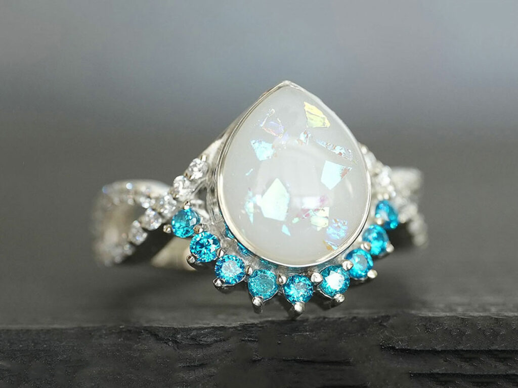 breastmilk jewelry ring with blue zircon December birth month color crystals around teardrop breastmilk stone from KeepsakeMom