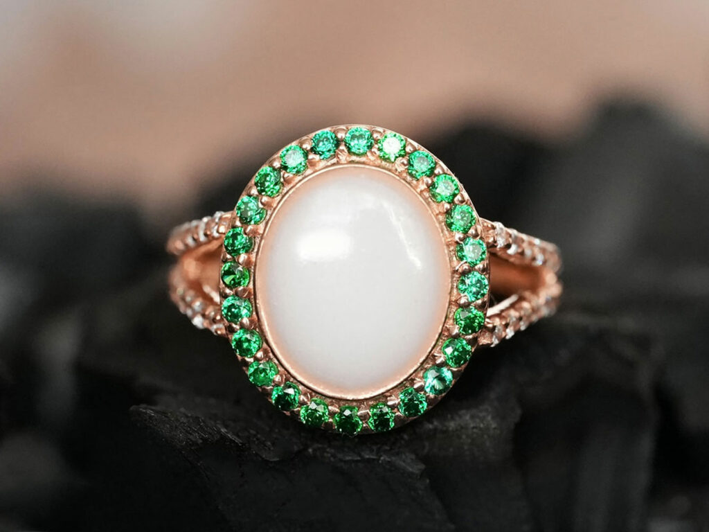 breastmilk jewelry ring with may green emerald birth month color crystals around oval breastmilk stone and rose gold band from KeepsakeMom