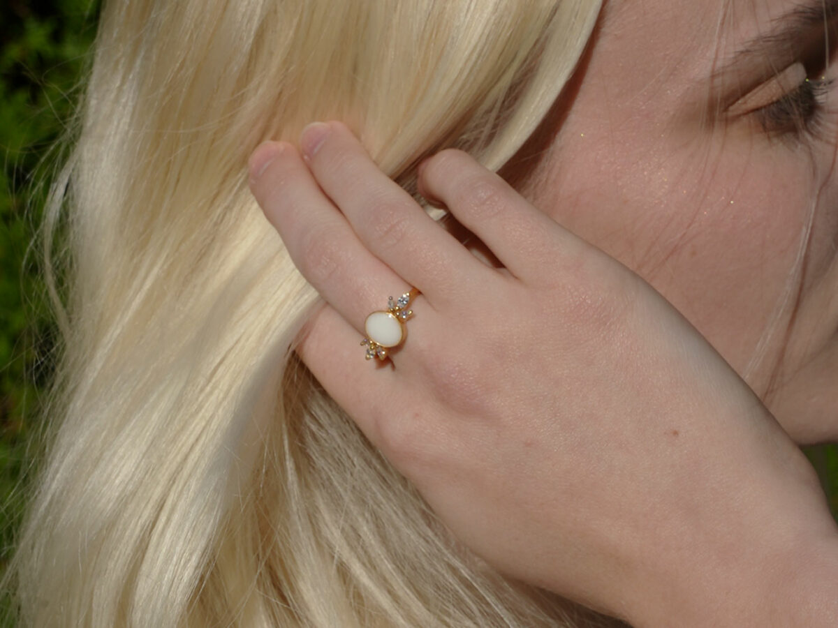 breastmilk jewelry model in white dress wearing yellow gold oval ring from KeepsakeMom