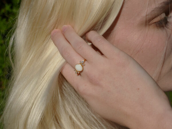 breastmilk jewelry model in white dress wearing yellow gold oval ring from KeepsakeMom