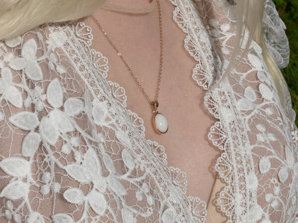 breastmilk jewelry model in white dress wearing oval necklace from KeepsakeMom