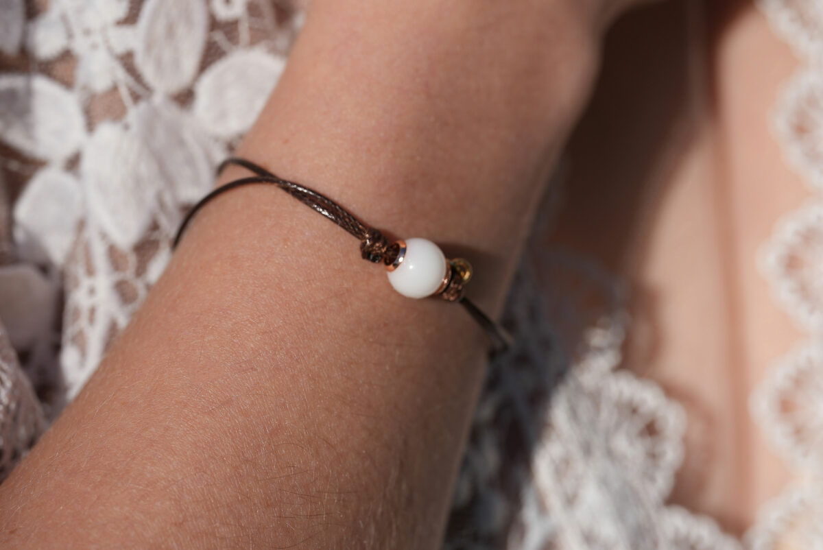 breastmilk jewelry model in white dress wearing bracelet from KeepsakeMom