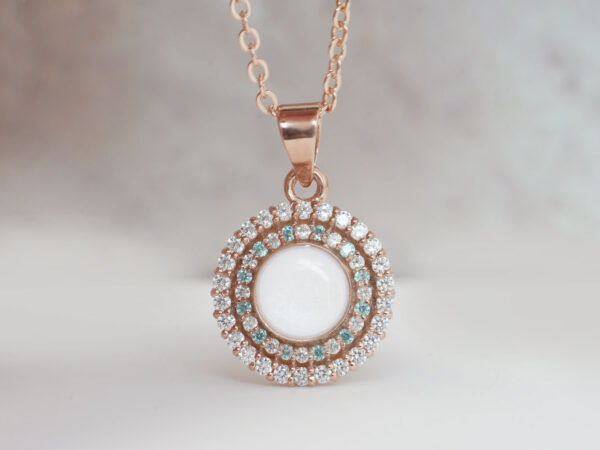 breastmilk-jewelry-ring-on-a-model-hand-close-up-in-rose-gold-with-crystals-of-birth-color-clear-and-aquamarine