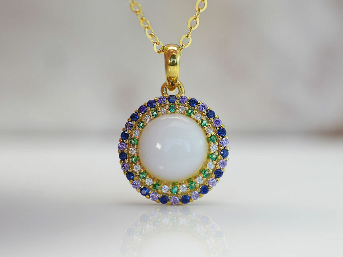 breastrmilk jewelry round disc necklace with double halo of purple and clear birth month color crystals from KeepsakeMom in gold with clear, green, purple and blue crystals alternating