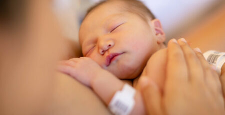 Sleeping newborn practicing kangaroo care in hospital