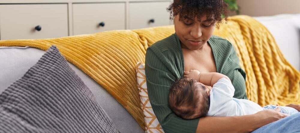 Woman breastfeeding baby on a couch