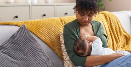 Woman breastfeeding baby on a couch