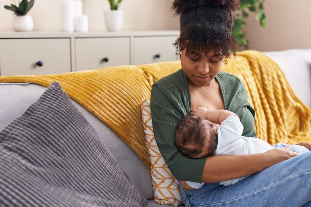 Woman breastfeeding baby on a couch