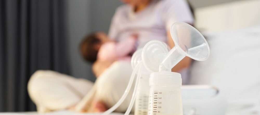 Mom and baby in the background of a full breast pump