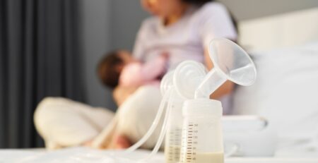 Mom and baby in the background of a full breast pump