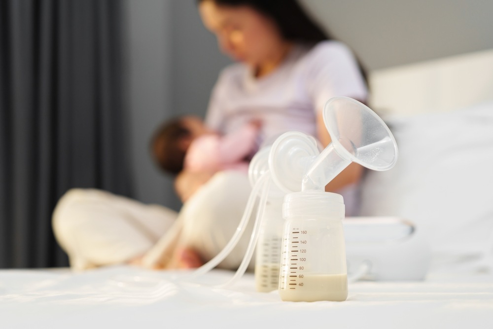 Mom and baby in the background of a full breast pump