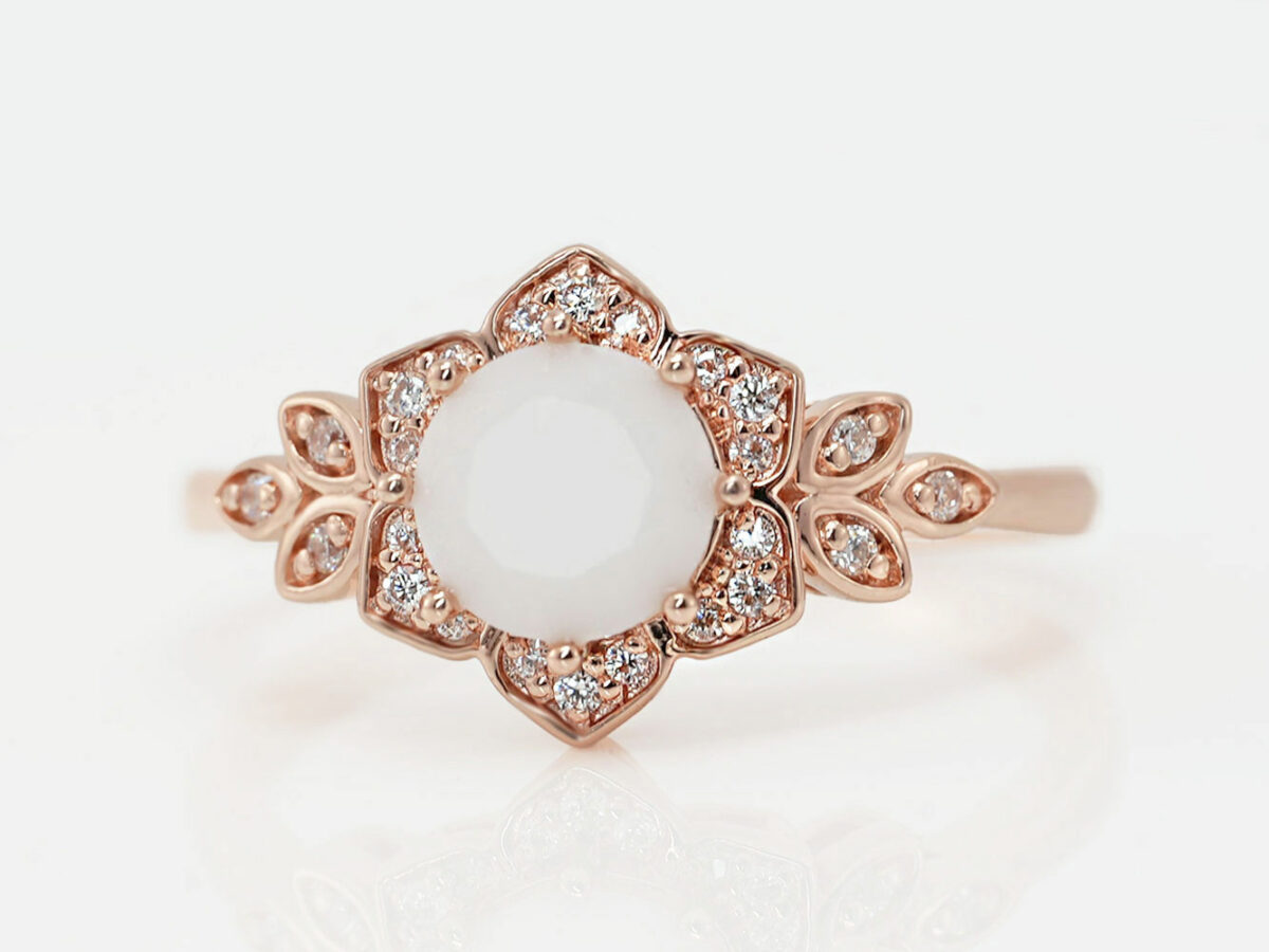 breast milk ring flower shaped rose gold with clear crystals on the side and central breast milk stone as a central diamond from keepsake mom