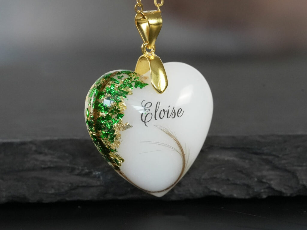 breastmilk jewelry yellow heart necklace with may emerald birth month color flakes on the side of breastmilk stone with name and hair from keepsakemom