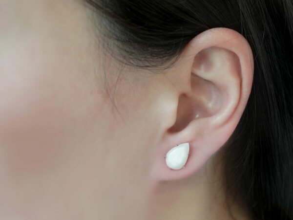 breastmilk jewelry earrings on a model ear from KeepsakeMom simple teardrop faceted studded