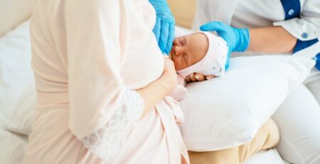 Lactation consultant helping a newborn latch