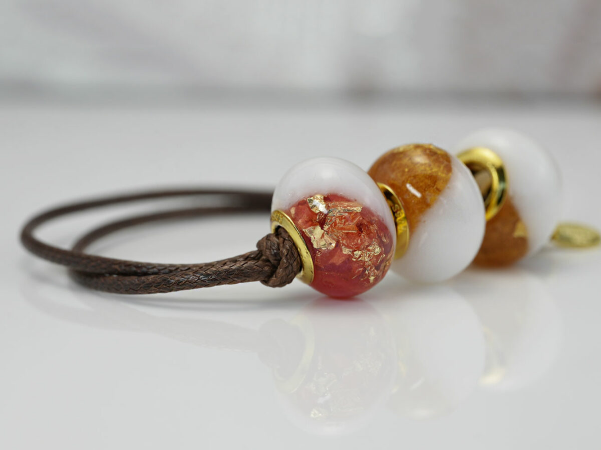 breastmilk three beads bracelet with birth month colors citrine and ruby on a waxed brown cord on white background from KeepsakeMom