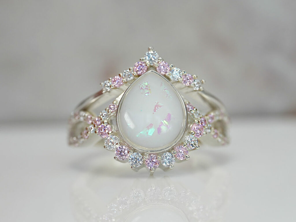 breast milk ring set with pink birth month crystals around teardrop shaped milk stone and white gold plating from keepsakemom