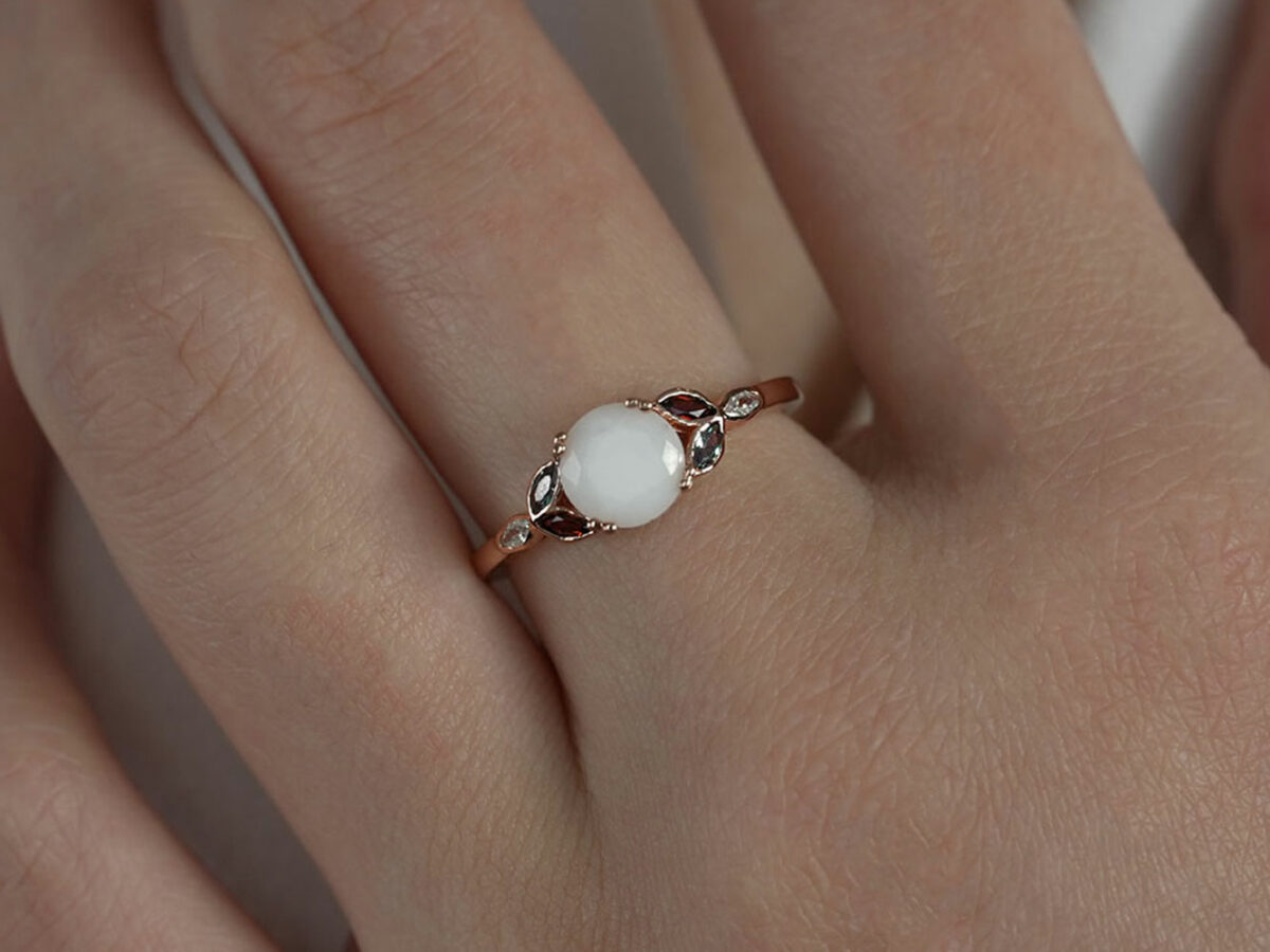 breastmilk ring diamond shaped stone leaves crystals on each side in birth month colors red and blue from Keepsakemom rose gold model hand
