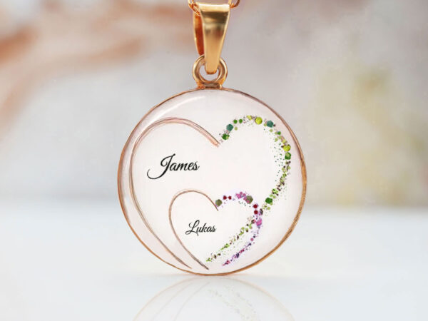 breastmilk jewelry necklace disc with two hearts made with baby hair, names and green and purple flakes making the other sides of the hearts from keepsakemom
