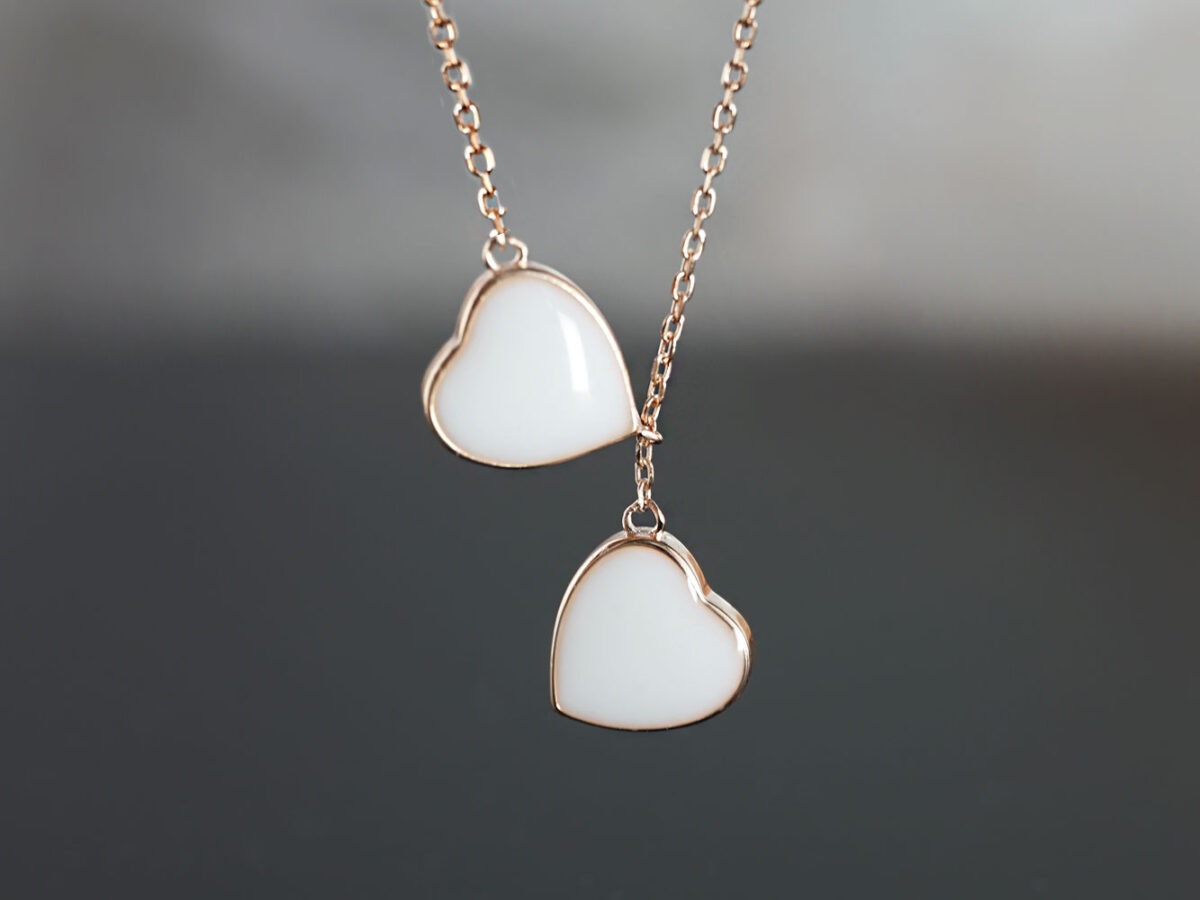 breastmilk jewelry two hearts intertwined filled with breast milk in rose gold setting on dark background from keepsakemom
