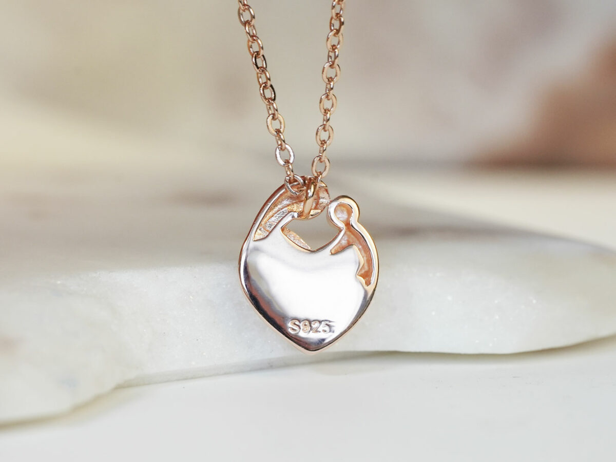 breastmilk jewelry heart necklace with mother and baby outline filled with breastmilk in rose gold setting from keepsakemom back of the pendant