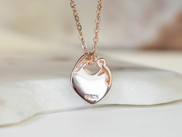 breastmilk jewelry heart necklace with mother and baby outline filled with breastmilk in rose gold setting from keepsakemom back of the pendant