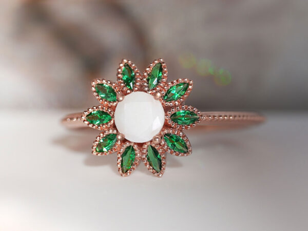 breast milk ring flower shaped rose gold with emerald green petals and central breast milk stone as a central diamond from keepsakemom