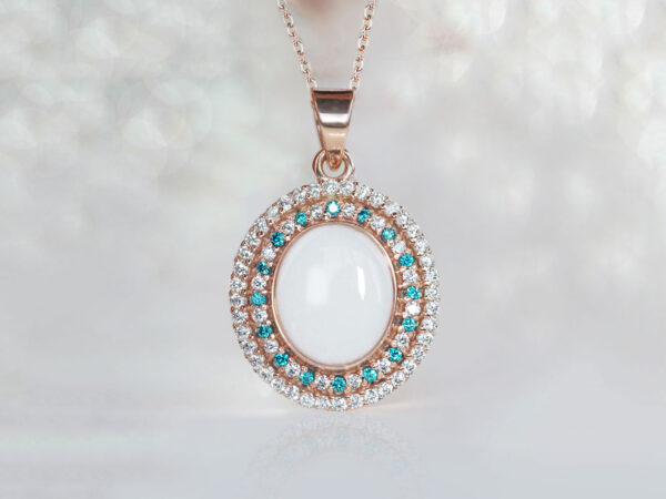 breastrmilk jewelry oval necklace with double halo of birth month color crystals from KeepsakeMom in rose gold with clear and aqua blue crystals alternating