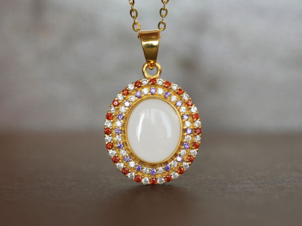 breastrmilk jewelry oval necklace with double halo of birth month color crystals from KeepsakeMom in yellow gold with clear, red and purple alternating