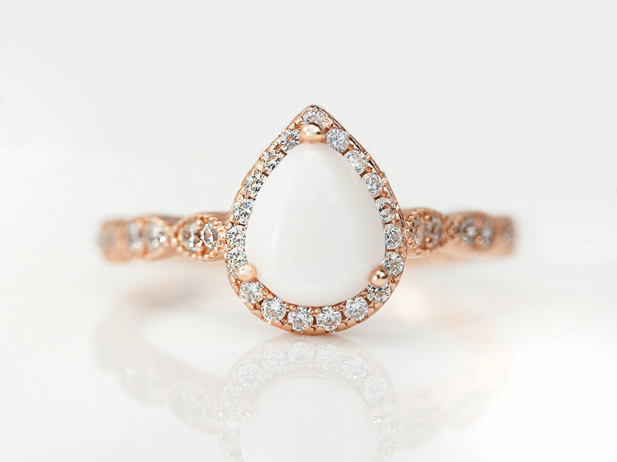 breastmilk jewelry ring in rose gold setting pear shaped milk stone crystals around the stone and band from Keepsakemom