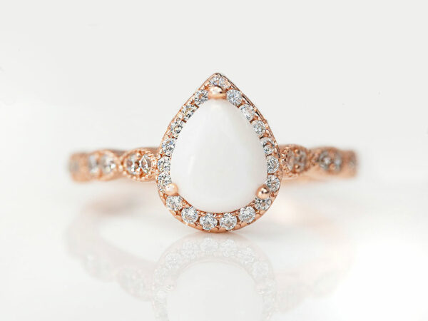 breastmilk jewelry ring in rose gold setting pear shaped milk stone crystals around the stone and band from Keepsakemom