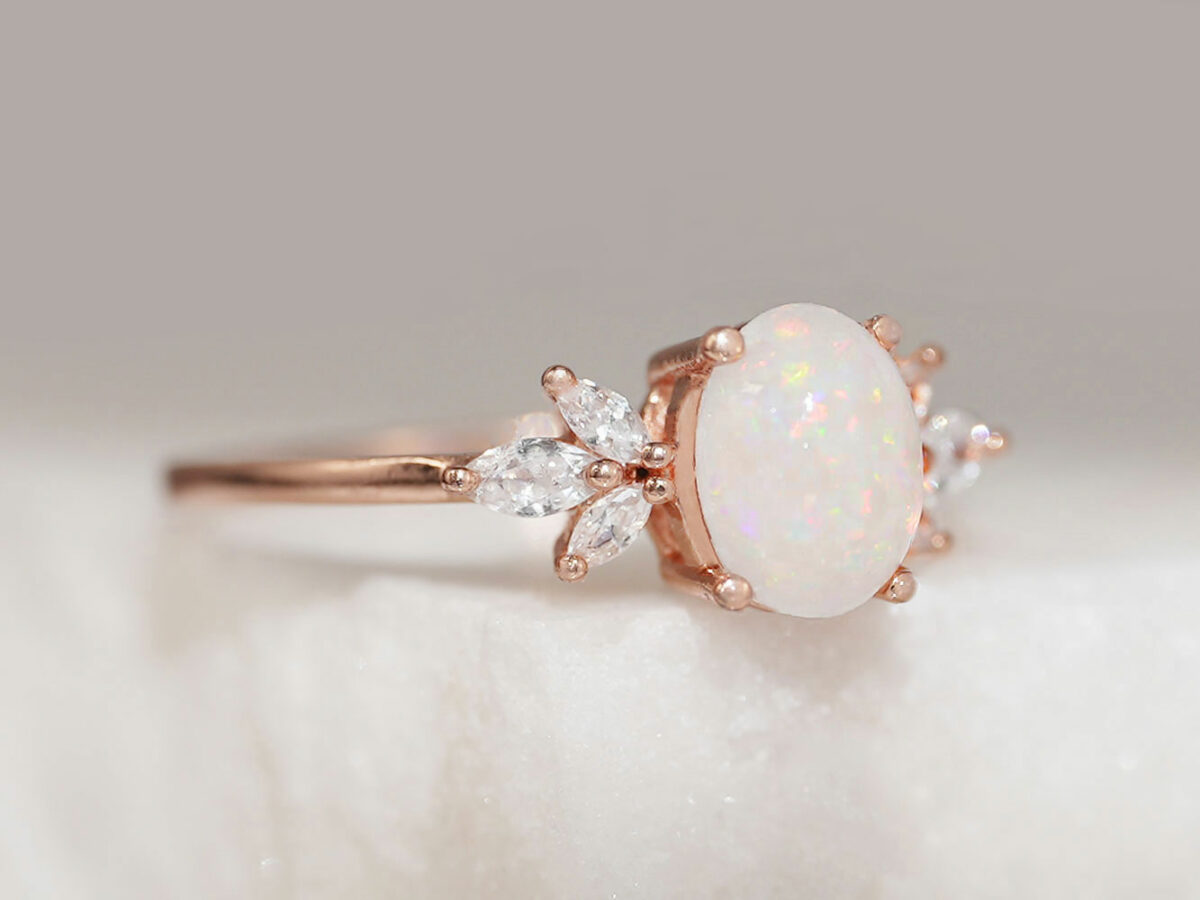 breastmilk ring burst of love oval with three crystals on each side from KeepsakeMom with crushed opal gems in the milk stone