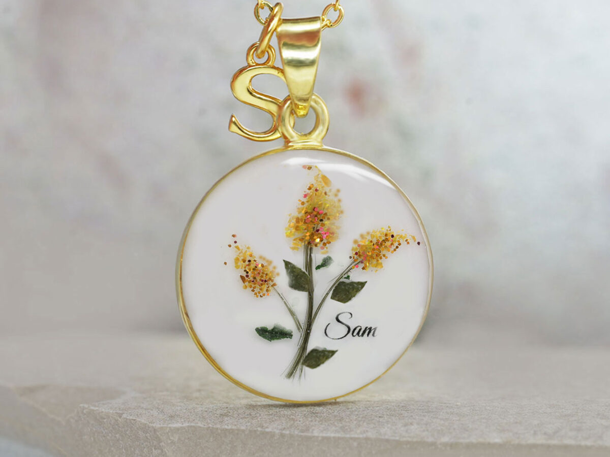 breastmilk jewelry yellow gold disc necklace with lock of hair making red lilacs stems with red gems and shimmers to make flowers with baby name from keepsakemom