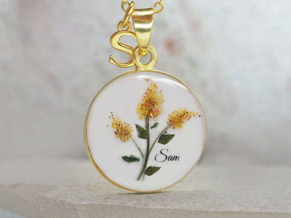 breastmilk jewelry yellow gold disc necklace with lock of hair making red lilacs stems with red gems and shimmers to make flowers with baby name from keepsakemom