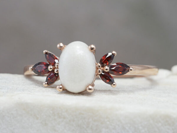 breastmilk ring burst of love oval with three garnet crystals on each side from KeepsakeMom with oval breastmilk stone