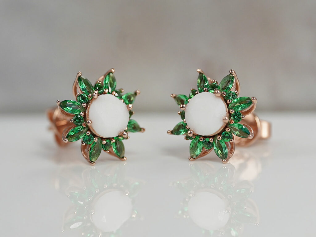 breastmilk jewelry flower shaped rose gold studded earrings with may emerald birth month color crystals gems around diamond shaped breastmilk central stone from keepsakemom