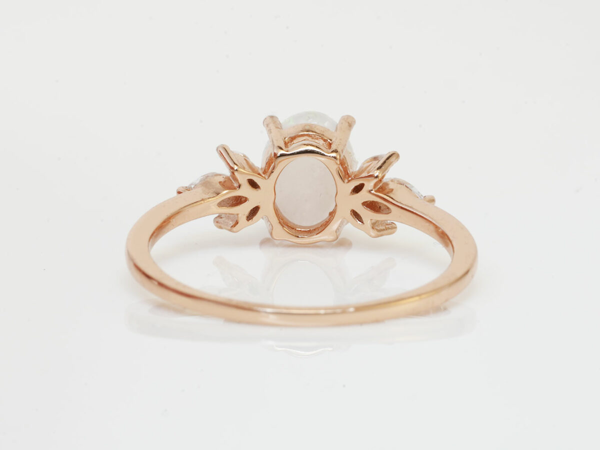 back of the breastmilk ring burst of love oval with three crystals on each side from KeepsakeMom with crushed opal gems in the milk stone