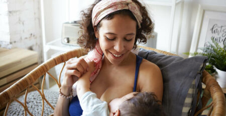 Mom breastfeeding baby in chair