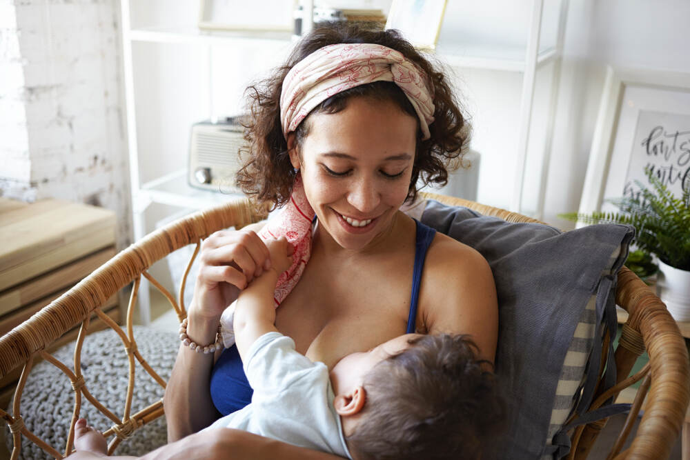 Mom breastfeeding baby in chair