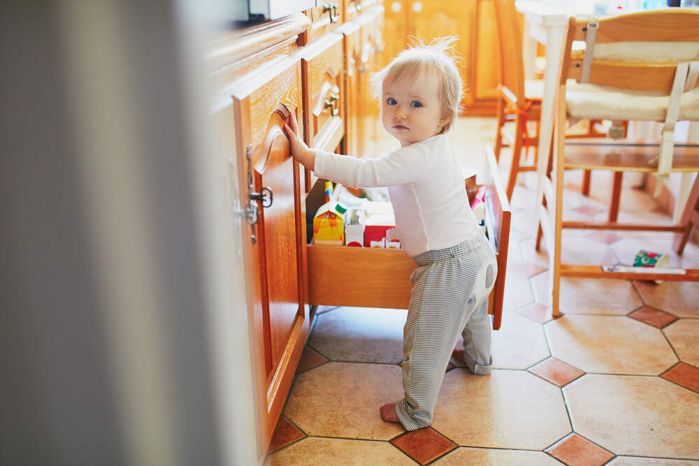 Toddler opening drawer in kitchen