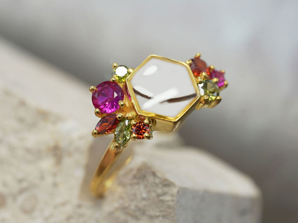 breastmilk jewelry ring in yellow gold in milk and honey hexagonal honeycomb shape with different birth month color gems around from keepsakemom side view and lock of hair in breastmilk stone