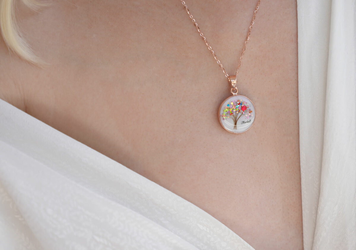 breastmilk jewelry disc necklace tree of life with baby's lock of hair and birth month color multicolored flakes tree KeepsakeMom on a model