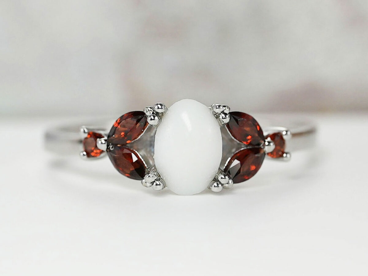 breast milk ring with oval stone and three ruby crystals or gems on each side in silver setting from KeepsakeMom