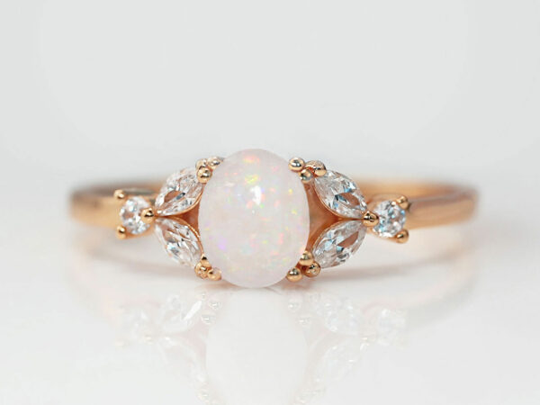 breast milk ring with oval stone with opals and three clear crystals or diamonds on each side in silver setting from KeepsakeMom
