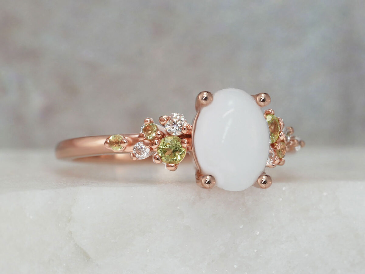 breastmilk oval stone ring with peridot and clear side crystals and rose gold setting from keepsakemom