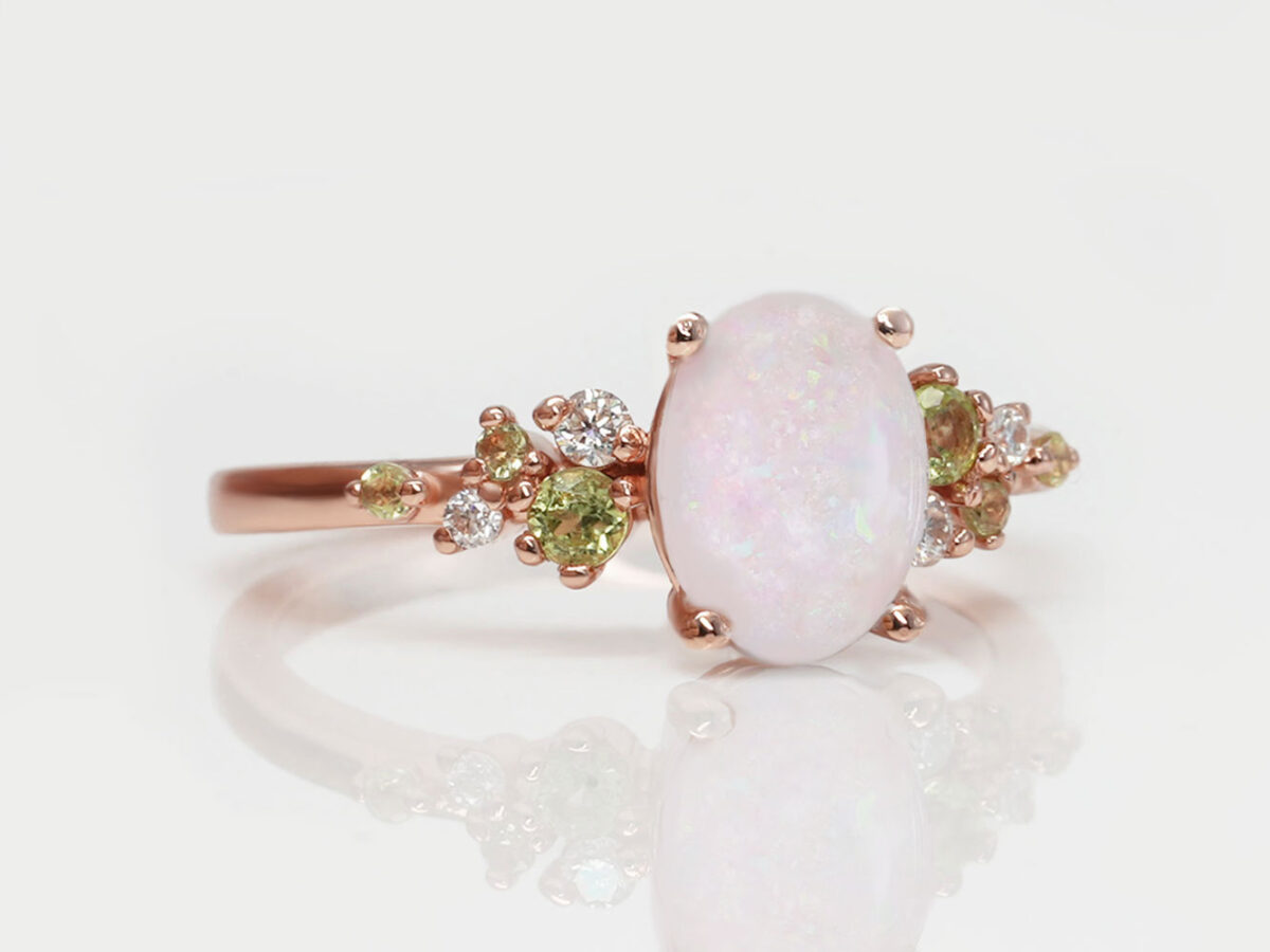 breastmilk oval stone ring with peridot and clear side crystals, crushed pink opal gems and rose gold setting from keepsakemom
